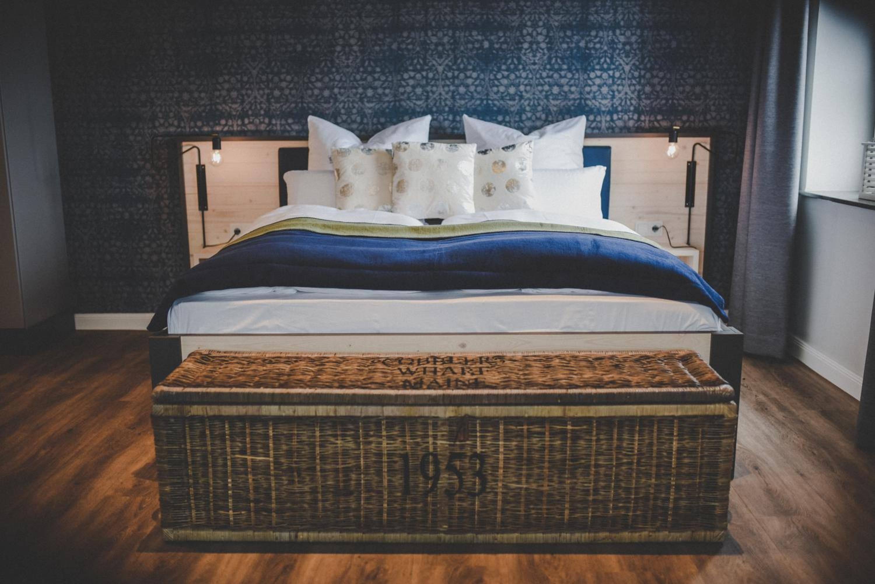 Ein Bett mit Kopfteil, Kissen und Decke.