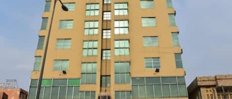 A multi-story hotel building with a central entrance and a sign indicating it is a hotel.