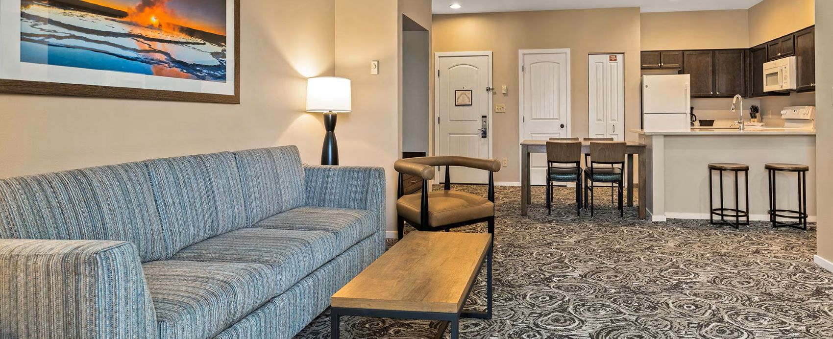 A living room with a sofa, a coffee table, a lamp, and a painting on the wall.