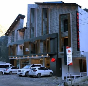 Un hotel amb una façana moderna, diverses finestres i un rètol que indica que és l'Hotel Mount Feast.