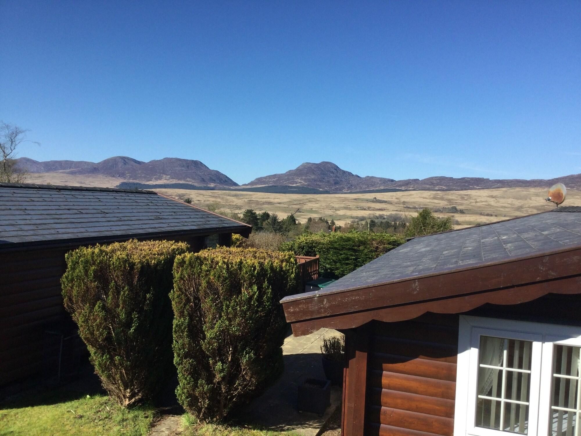 Une cabane avec vue sur les montagnes, un ciel dégagé et une antenne parabolique.