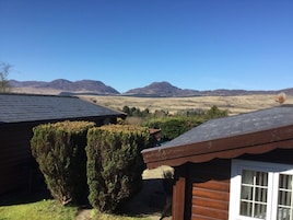 Una cabaña con vista a montañas, cielo despejado y una antena parabólica.