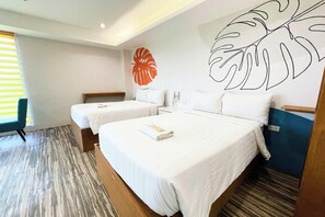 A hotel room with two beds, a large wall art of a leaf, a telephone, and a chair. - Lea Robert Hotel Angeles Pampanga (Angeles City)