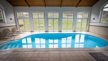 Una piscina con vistas a un viñedo a través de amplias ventanas.