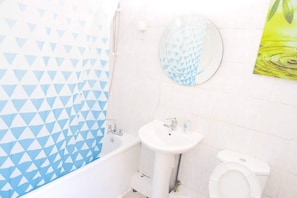 A bathroom with a bathtub, sink, and toilet.