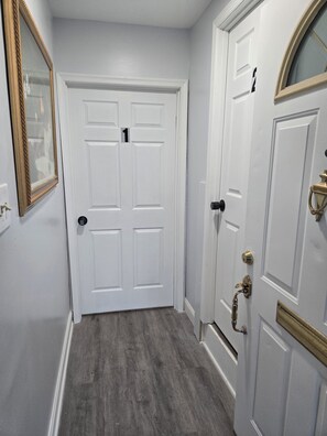 A hallway with two white doors, one marked with the number 1, and a door with a brass handle.