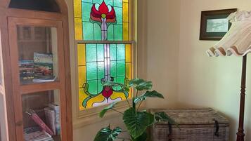 A room with a wooden cabinet, a wicker chest, and a large green plant.