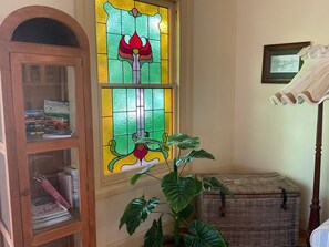 A room with a wooden cabinet, a wicker chest, and a large green plant.