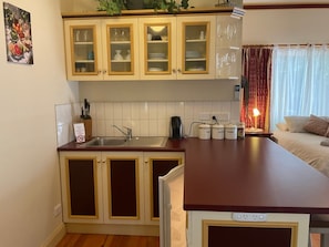 Una cucina con mobili in legno, un piano di lavoro, un lavello e una macchina per il caffè.