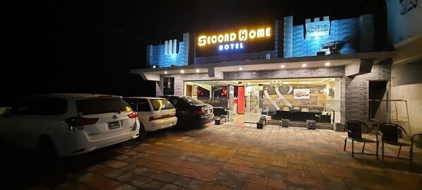 A hotel with a sign reading 'Second Home Hotel' and a parking area with several cars. - Hotel Second Home (Murree)