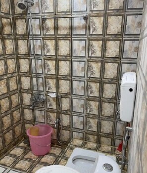 Un baño con inodoro, ducha y secador de manos.