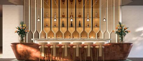 A bar area with a marble countertop, wicker chairs, and a patterned wall with bottles.