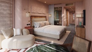 Ett modernt hotellrum med en stor säng, en sittgrupp, ett badrum med handfat och en hall som leder till andra rum.