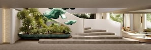 Un interior moderno con una escalera, plantas de interior y una zona de estar con cojines.
