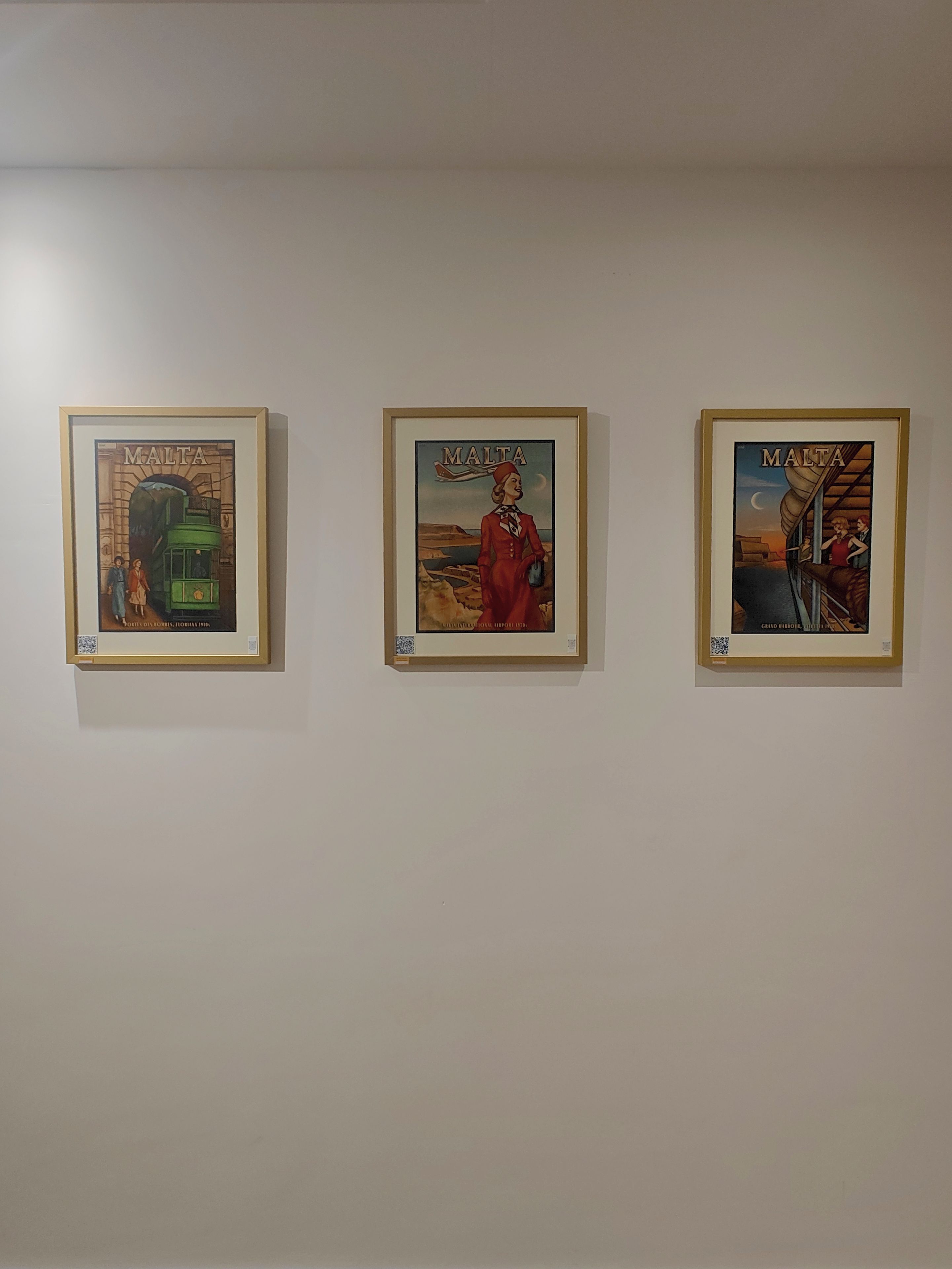 Drei gerahmte Kunstwerke an einer Wand.