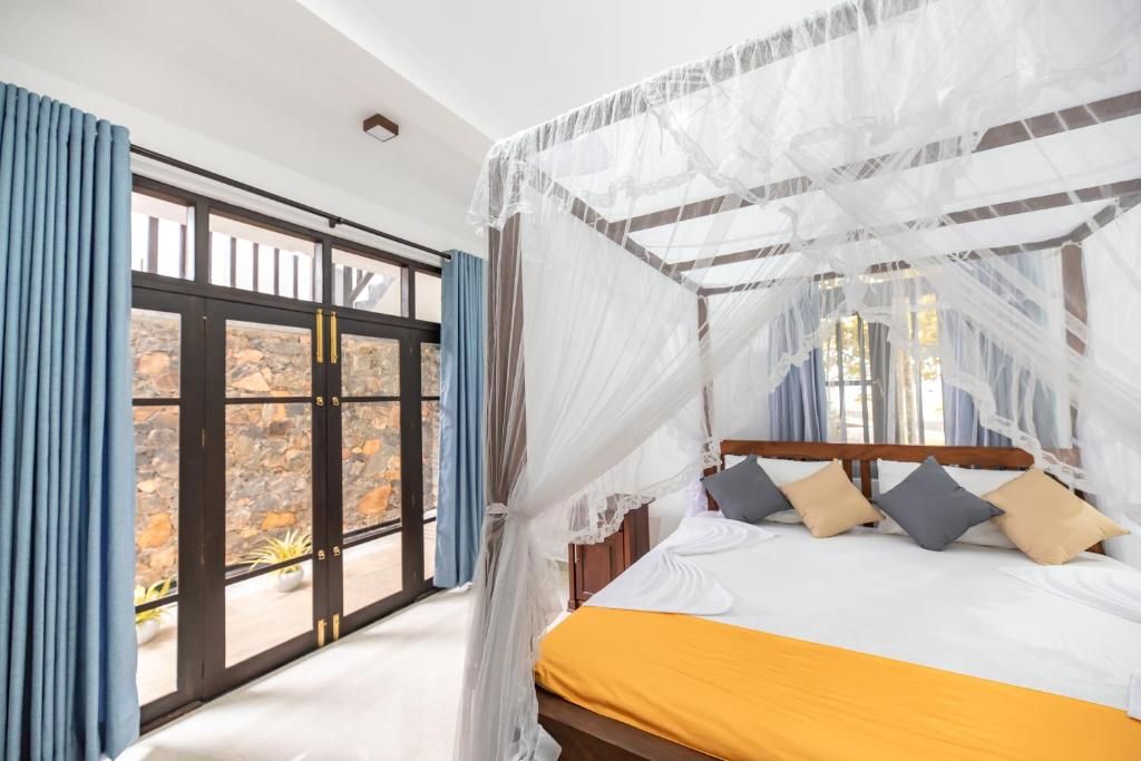 A bedroom with a bed, curtains, and a view through a glass door.