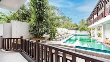 Zona de piscina con vista despejada, rodeada por un muro blanco y una valla de madera.