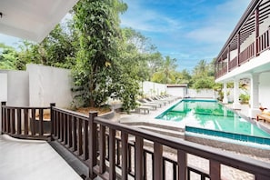 Zona de piscina con vista despejada, rodeada por un muro blanco y una valla de madera.