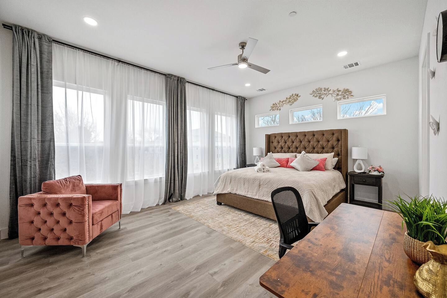 Ein modernes Schlafzimmer mit einem großen Bett, einer Sitzecke und einem Esstisch.