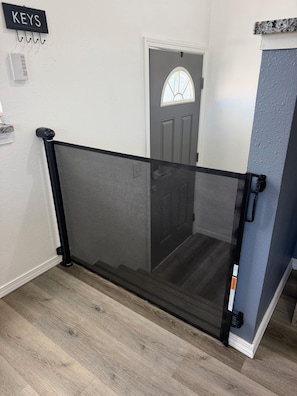 Ein schwarzes Metallgitter mit einem Maschendraht, eine Tür mit einem satinierten Fenster und ein Schild mit der Aufschrift 'KEYS' an der Wand.