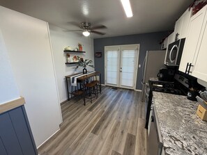 Eine Küche mit Essbereich, Holzboden, Deckenventilator und Mikrowelle.