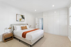 A bedroom with a bed, bedside tables, a wardrobe, and a painting on the wall. - Harbourside Retreat | 1 min Walk from Ferry to CBD (Cremorne Point)