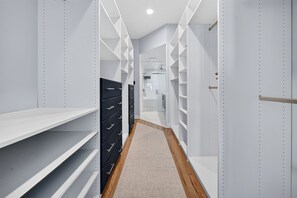 Ein schmaler Korridor mit weißen Regaleinheiten und Holzboden.
