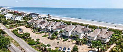 A coastal residential area with beachfront properties, a main road, and a parking lot.