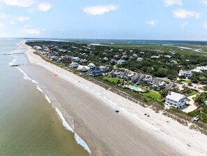 Ein Küstenwohngebiet mit Strandhäusern, einem Strand und blauem Himmel.