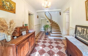 A hallway with a checkered floor, a wooden console table, a potted plant, and a staircase. - 5 bedroom gorgeous home in Sainte-Marthe (Sainte-Marthe)