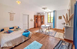 A bedroom with a bed, a desk, and a chair. There is a window with curtains, a radiator, and a wall-mounted shelf with decorative items. - 5 bedroom gorgeous home in Sainte-Marthe (Sainte-Marthe)