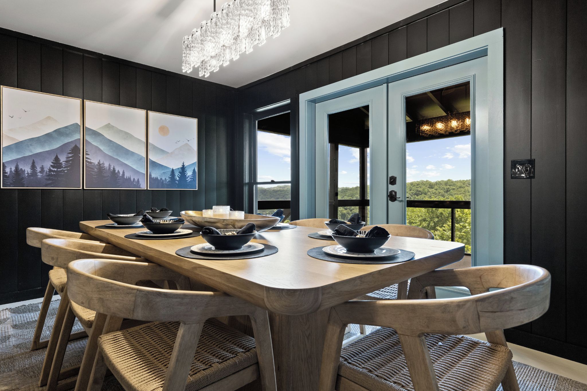 A dining area with a wooden table, chairs, and artwork on the wall.