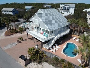 A two-story house with a balcony, a swimming pool, and a fenced deck area. - The Wave | Entire 10BR Duplex | 2 Private Pools | Steps to Beach (Grayton Beach)