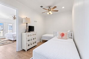 A bedroom with two beds, a dresser with drawers, a ceiling fan, and a lamp. - The Wave | Entire 10BR Duplex | 2 Private Pools | Steps to Beach (Grayton Beach)