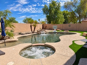 A swimming pool with a hot tub, surrounded by a brick wall, palm trees, and a basketball hoop. - 1 mile to Spring Training - Backyard Oasis - Pool Hot Tub -4BR Single Level Home (Goodyear)