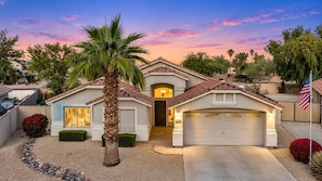 A residential house with a garage, a driveway, and a well-maintained lawn.