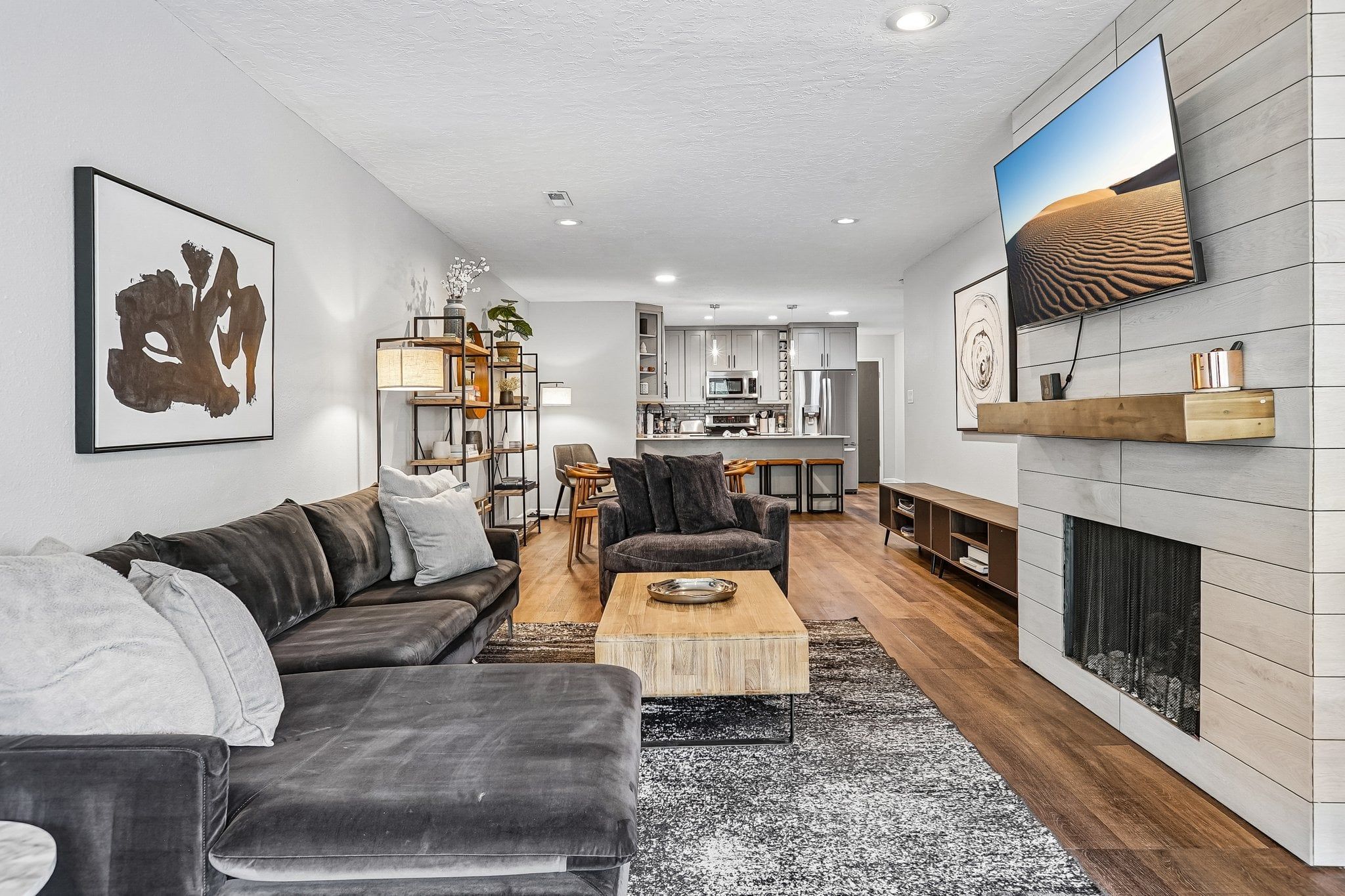 A modern living room with a sofa, coffee table, and fireplace.