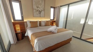 Une chambre d’hôtel avec un grand lit, une lampe de chevet, une fenêtre avec des stores et une œuvre d’art accrochée au mur.