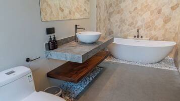 Ein modernes Badezimmer mit Toilette, Waschbecken und Badewanne.