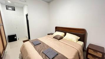 Una habitación de hotel con cama, mesitas de noche y un armario.