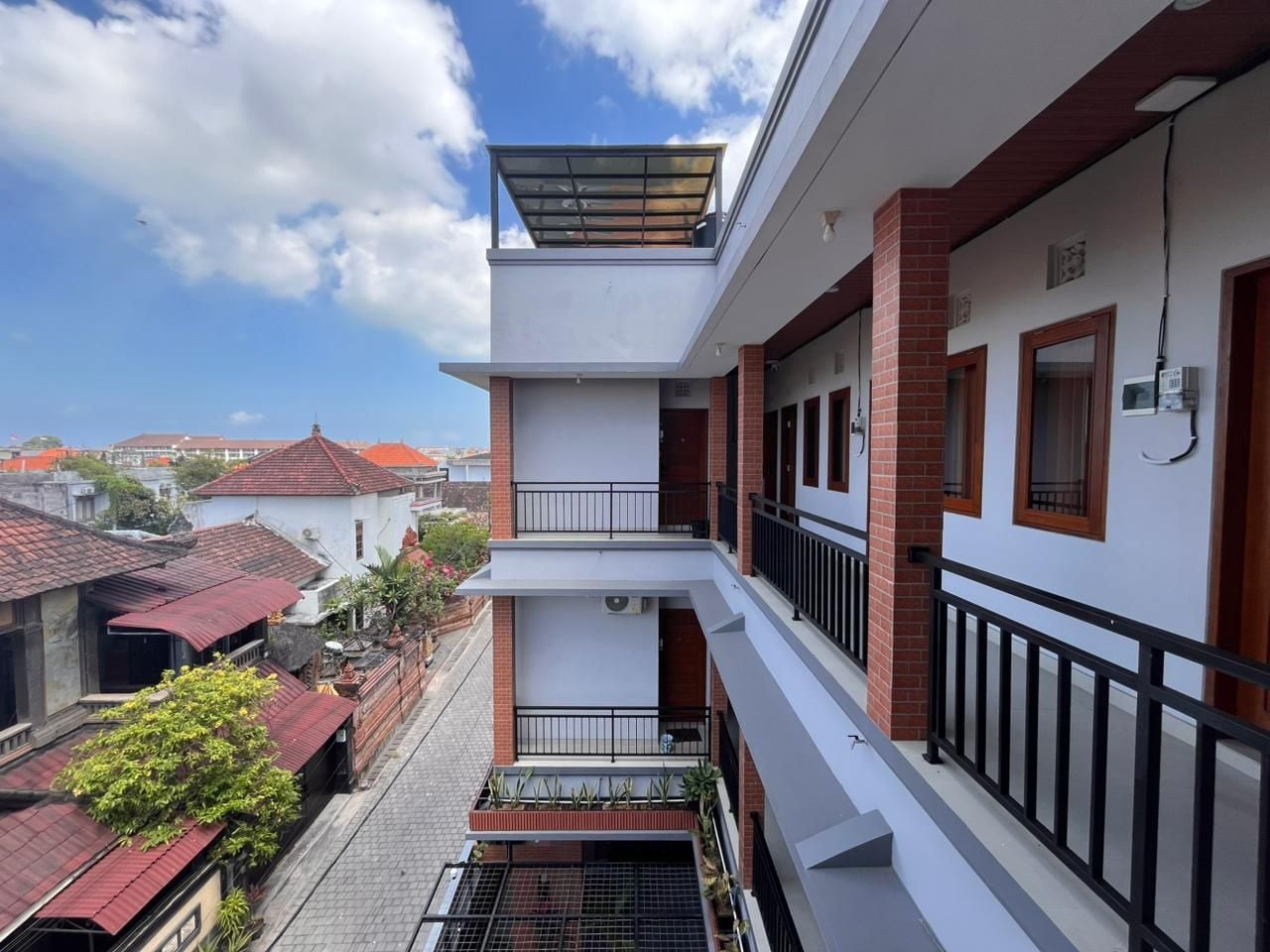 Un edificio residencial de varios pisos con balcones, techo plano y cielo despejado.