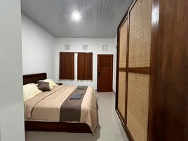 Quarto com cama, duas portas e uma janela grande com vista.