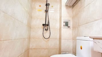 A bathroom with a shower, toilet, and a towel rack.