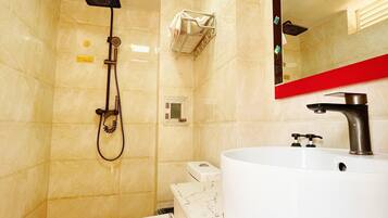 A bathroom with a white sink, a toilet, a showerhead, and a mirror with a red frame.