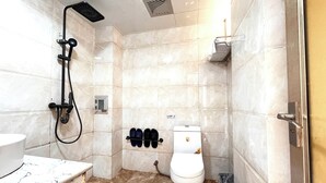 Un baño con ducha, inodoro y lavabo.