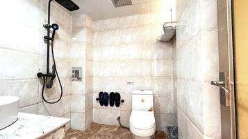 Un baño con ducha, inodoro y lavabo.