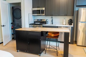 Une cuisine compacte équipée d’un four à micro-ondes, d’une cuisinière et d’un évier intégrés.