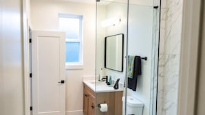 Ein modernes Badezimmer mit Toilette, Waschbecken und Duschkabine.