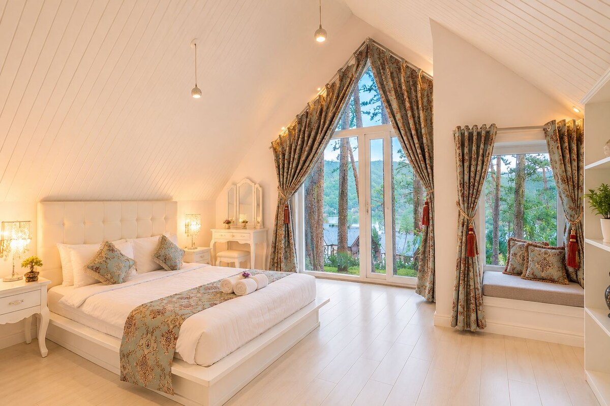 Quarto com cama grande, mesa de cabeceira, cômoda e janela com cortinas.