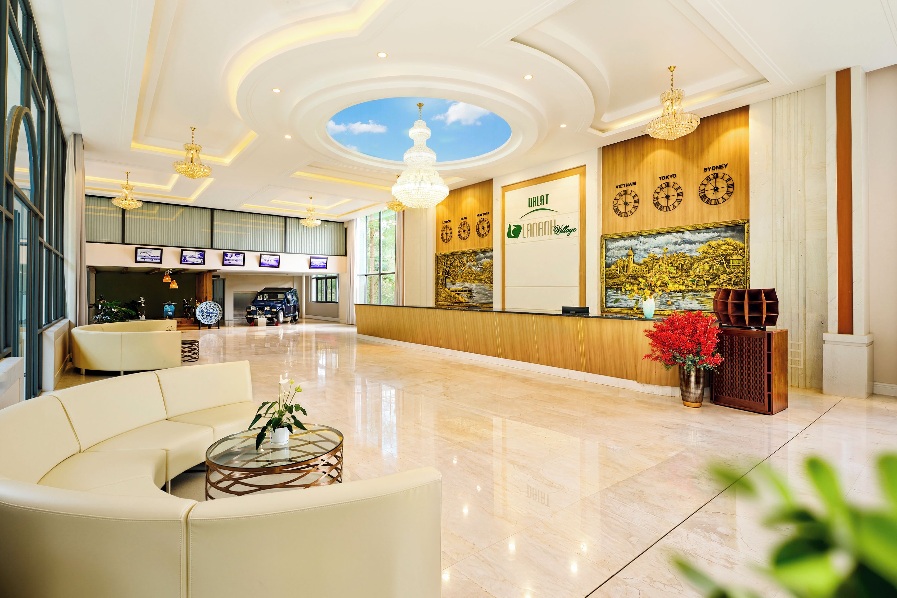 Un vestíbulo de hotel con mostrador de recepción, zona de estar y un gran ventanal.